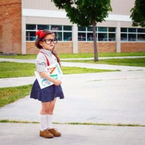 little girl waiting outside a school