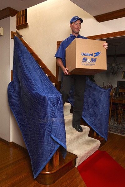 man carrying box down stairs