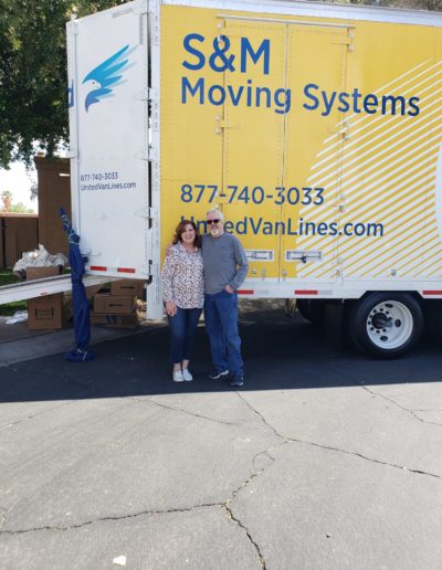 Happy customers in front of S&M Moving truck