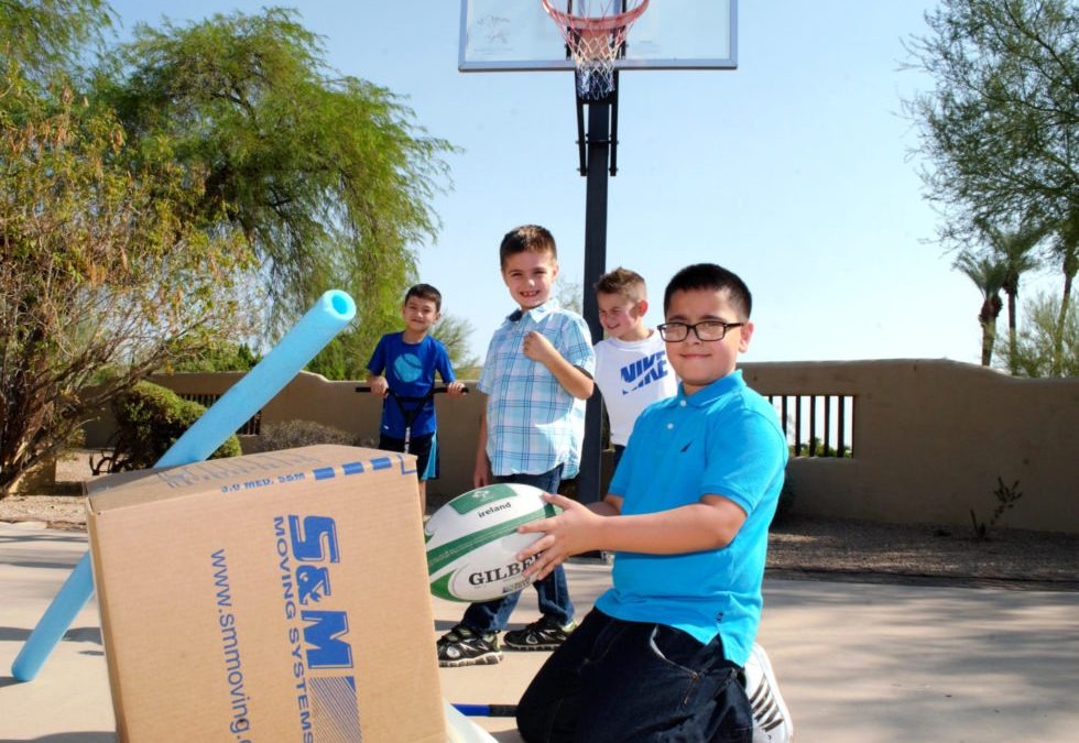 children on a basketball court with moving boxes listening to tips on moving with kids and pets
