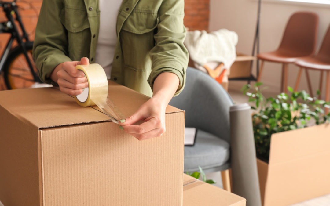 Woman packing moving box at home using tips for packing your house to move