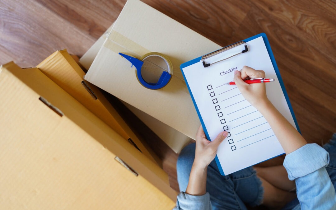 Top view of woman checking package with moving checklist at home